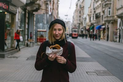 Portrait of young woman standing on street