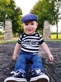 Portrait of smiling boy sitting on tree