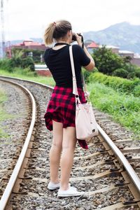 Woman standing on railroad track