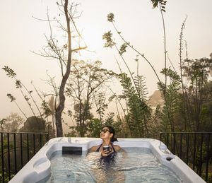 Woman enjoying a bath in a hot tub in the sri lankan highlands