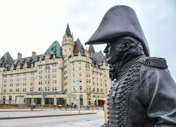 Low angle view of statue of historic building against sky