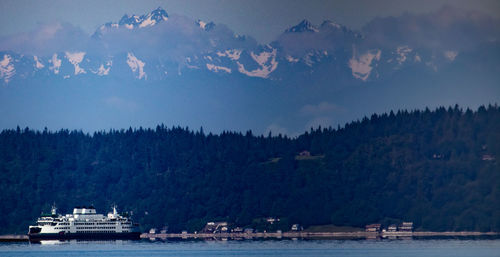 Scenic view of sea by mountains against sky