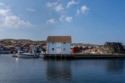 Houses by sea against sky in city