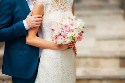 Midsection of woman holding flower bouquet