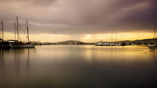 Sailboats in marina at harbor against sky