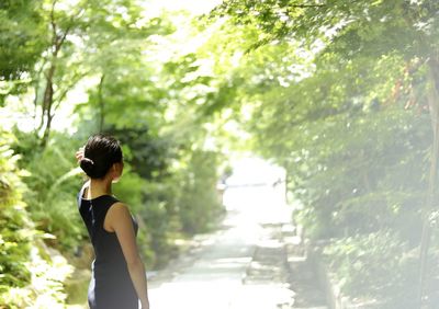 Woman looking away while standing in public park