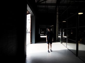 Rear view of woman walking in corridor of building