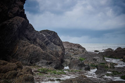 Rock formations by sea against sky