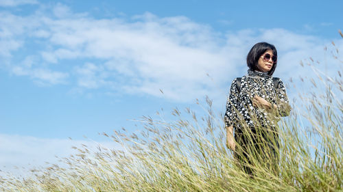 Woman standing on field against sky