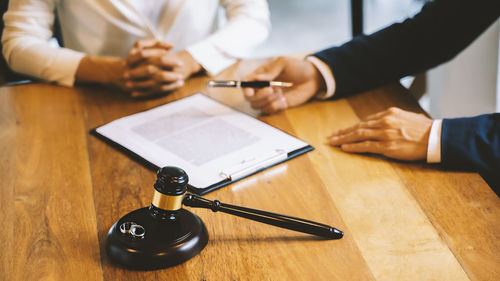 High angle view of people holding hands on table