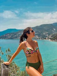 Portrait of young woman wearing sunglasses while swimming in sea