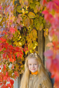 Vertical portrait of a smiling beautiful little blonde girl with in a not hat against