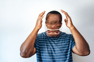 Portrait of young woman with arms crossed against white background