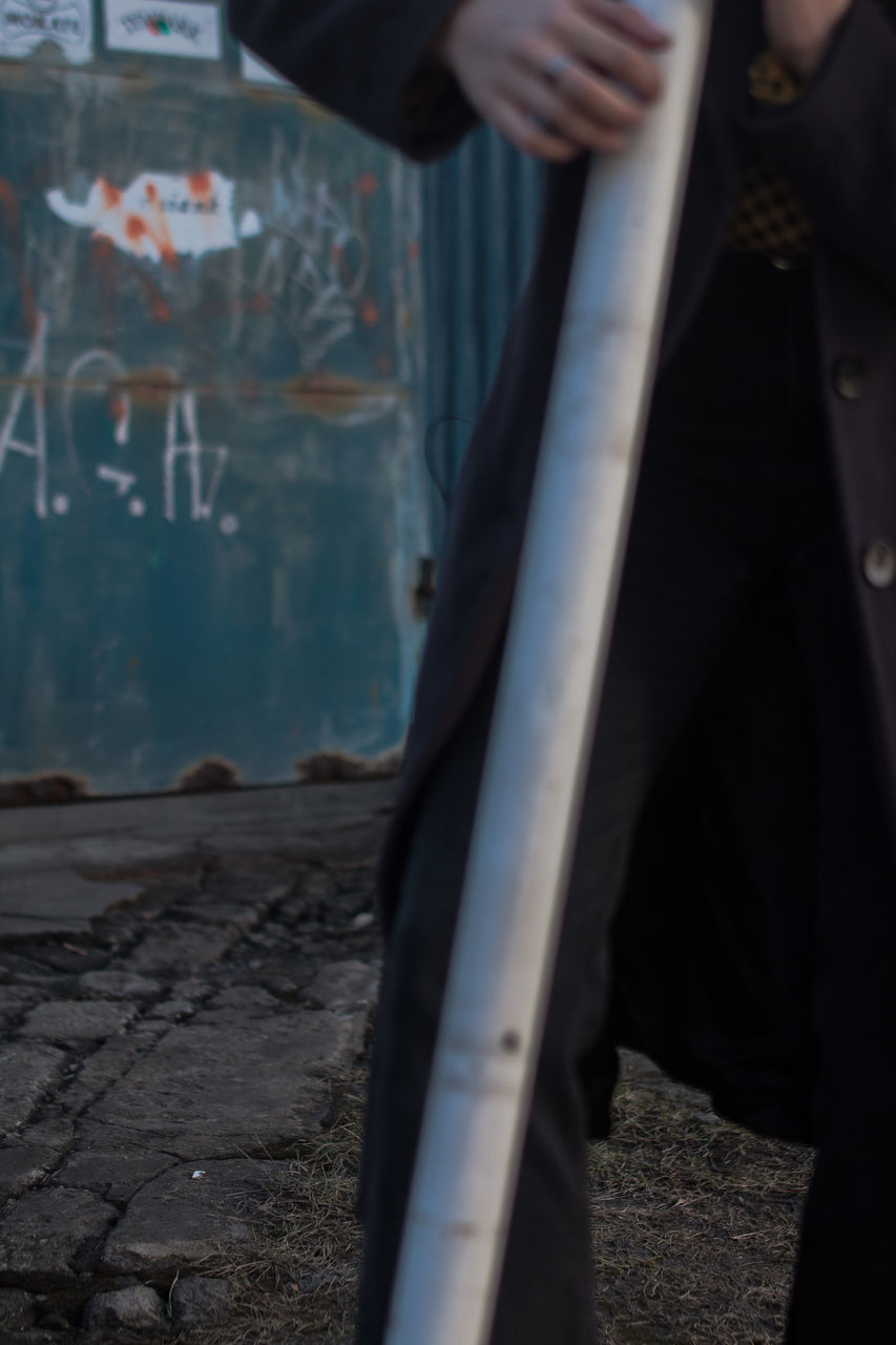 LOW SECTION OF MAN STANDING ON WET CITY