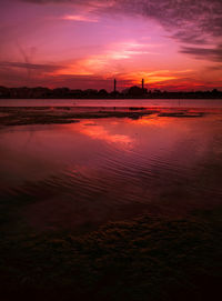 Scenic view of sea against dramatic sky during sunset