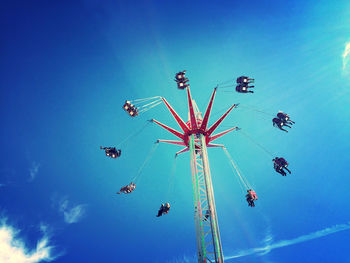 Low angle view of chain swing ride against clear blue sky