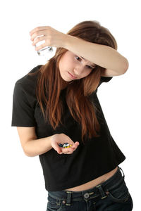 Midsection of woman holding smart phone while standing against white background