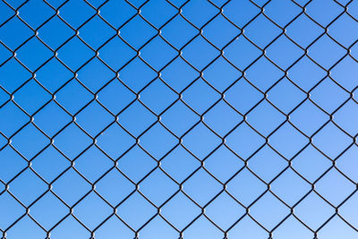 Chainlink fence against clear blue sky