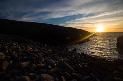 Scenic view of beach against sky during sunset