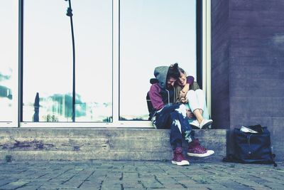 Friends laughing while sitting against door