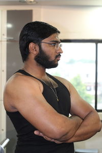 Muscular man with arms crossed looking away