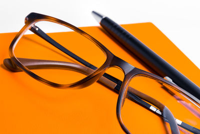 High angle view of eyeglasses on table against yellow background