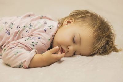 Portrait of cute baby boy sleeping on bed