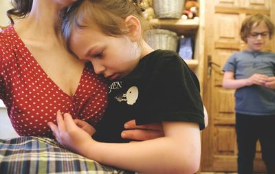 Midsection of mother consoling daughter at home