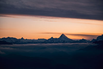 Scenic view of snowcapped mountains against sky during sunset