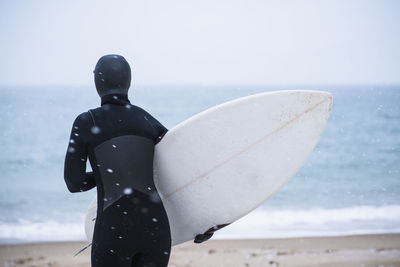 Young woman going winter surfing in snow