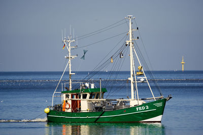 Sailboat sailing in sea against clear sky