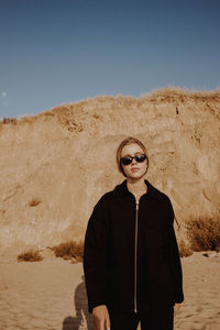 Portrait of man wearing sunglasses standing against sky