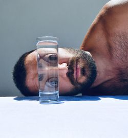 Close-up of man drinking glass on table