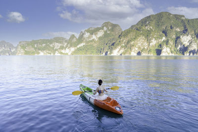 Young woman kayaking among the sea and mountains during a trip in thailand. amazing thailand
