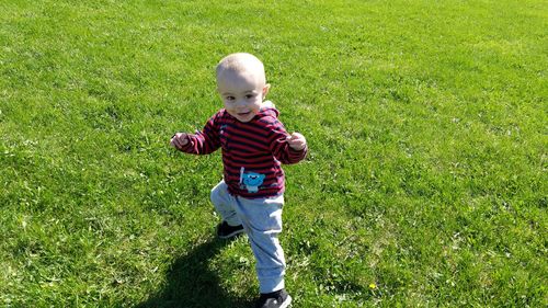 High angle view of playful baby boy gesturing on grass