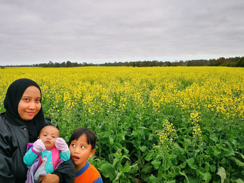 Portrait of woman with children against flowering plants