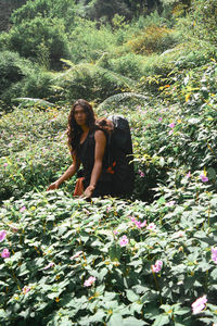 Woman sitting on flowering plant