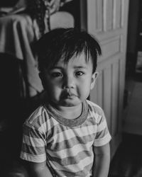 Sad baby with real emotion in a dark mood black and white photo. 
