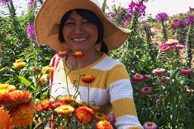Portrait of smiling woman with red flowers
