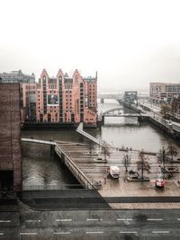 Bridge over river in city against clear sky