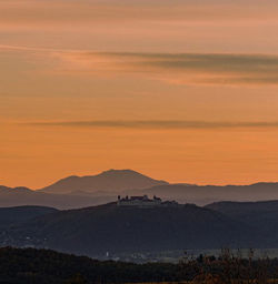 Scenic view of silhouette mountains against orange sky