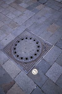 High angle view of manhole on footpath