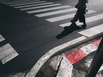 Low section of woman walking on road