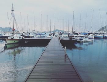 Sailboats moored at harbor