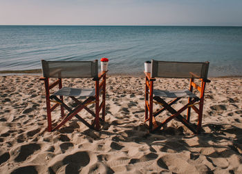 Two chairs in front of the seashore 