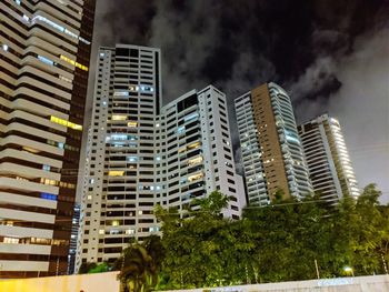 Low angle view of buildings against sky at night