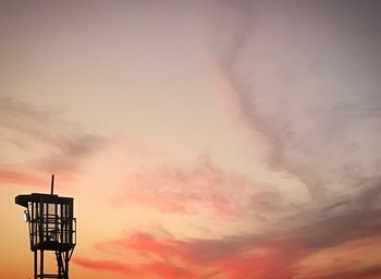 Low angle view of silhouette crane against sky during sunset