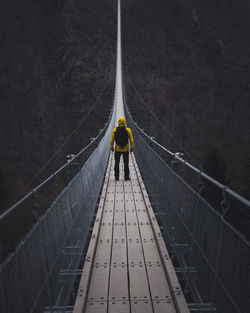 Man standing on footbridge