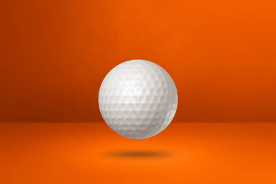 Close-up of ball on table against orange background