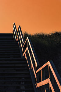 Low angle view of staircase against sky during sunset
